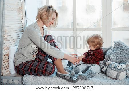 Mother With A Little Daughter. Family In Home Clothes.