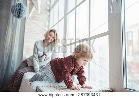 Mother With A Little Daughter. Family In Home Clothes.