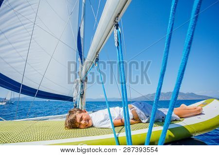 Little Boy On Board Of Sailing Yacht On Summer Cruise. Travel Adventure, Yachting With Child On Fami