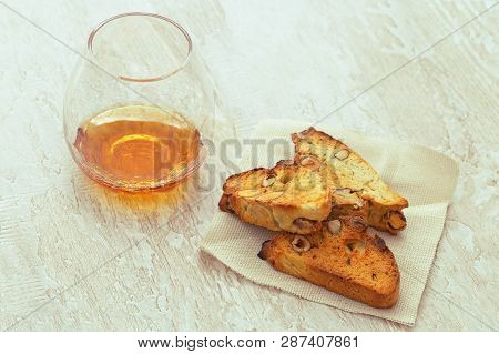 Italian Dry Cookies Cantucci Or Biscotti With Sweet Wine On Wooden Table.   Selective Focus.