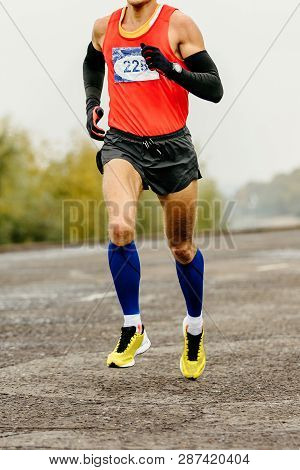 Athlete Runner In Compression Socks And Arm Sleeves Runnning Marathon