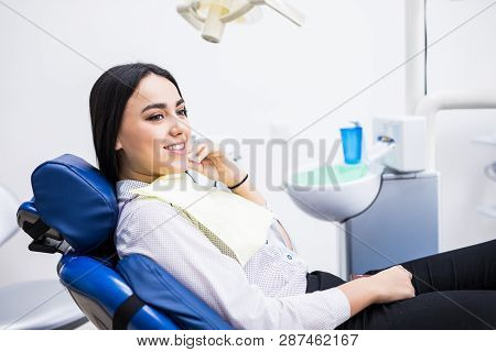 Overview Of Dental Caries Prevention. Woman At The Dentist's Chair During A Dental Procedure. Beauti