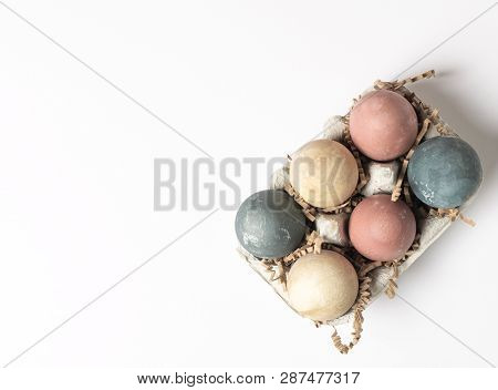 Selective Focus Of Coloured Decorated Easter Eggs In Cardboard Container, Minimal On White