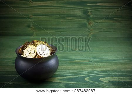 Gold Coins In Caldron For St. Patricks Day On Green Wooden Background