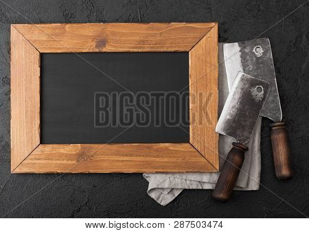 Wooden Menu Board And Vintage Meat Knife Hatchets On Kitchen Towel And Black Stone Table Background.