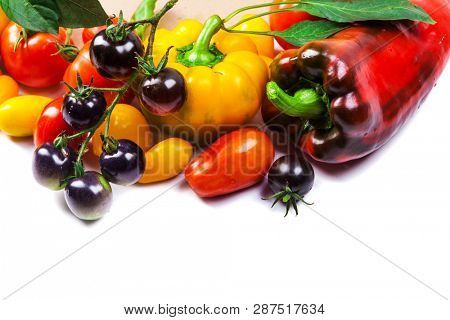 Assorted tomatoes and vegetables isolated on white background. Photo for your design
