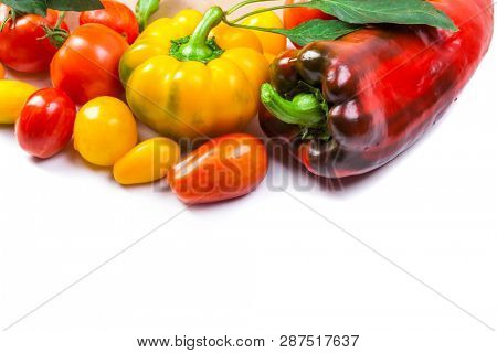 Assorted tomatoes and vegetables isolated on white background. Photo for your design