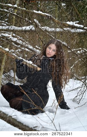 Woman Sitting In A Cold Winter Forest