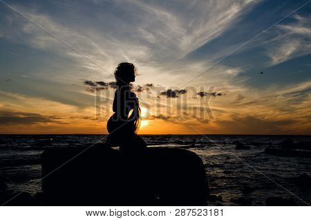 Silhouette Of Woman At The Orange Sunset