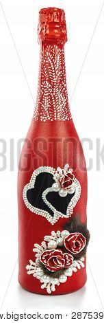A Bottle Of Champagne Decorated With Two Hearts, Beads, Fur. Champagne Is Painted Red And Decorated.