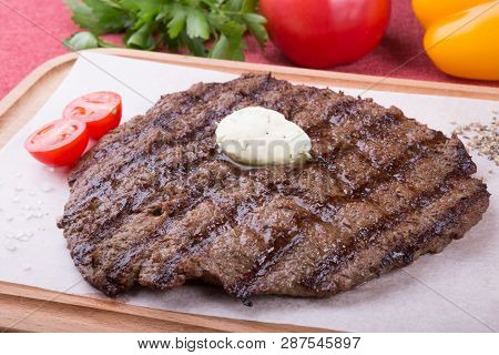 Prepared Steak Served With Butter On Wooden Board