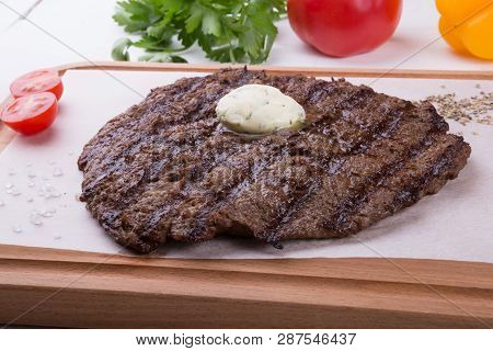 Prepared Steak Served With Butter On Wooden Board