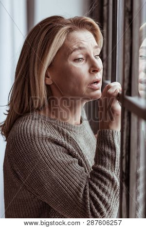 Woman Feeling Emotional And Sad Standing Near The Window