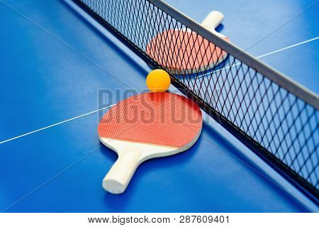 Pingpong Rackets And Ball And Net On A Blue Pingpong Table