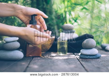 Spa Background With Woman's Hands And Clear Water On An Old Wooden Table. Japanese Style. Simplicity