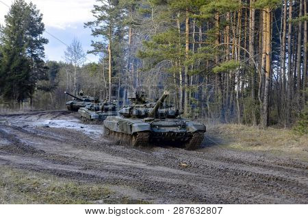 Russian Battle Tanks On The Exercises In The Forest Area