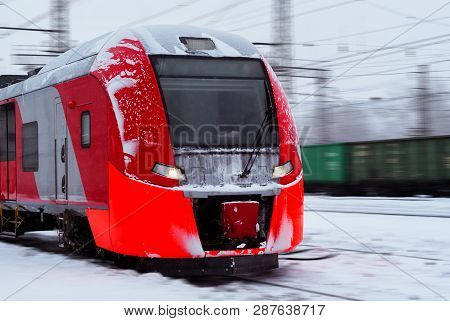 Ice-covered Electric Multiple Unit Train Rushes Along A Blurred Winter Railway Landscape