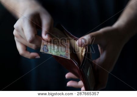No Money In Pocket Concept. Man Showing His Empty Wallet On Black Background. Cost Control Expenses 