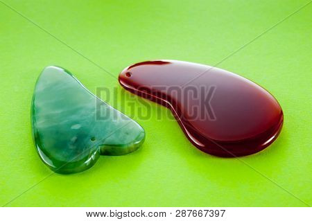 Guasha Scrapers For Body Massage According To The Ancient Method Shot On A Bright Green Background