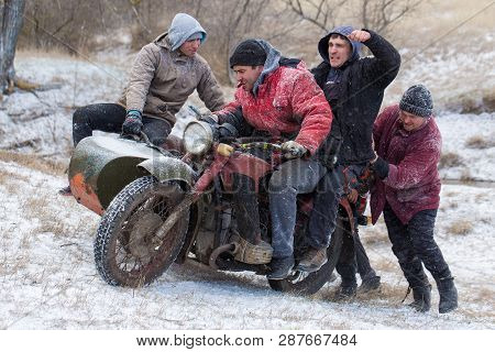 A Team On A Soviet Retro Motorcycle With A Sidecar In The Mud And Snow Riding Cross-country