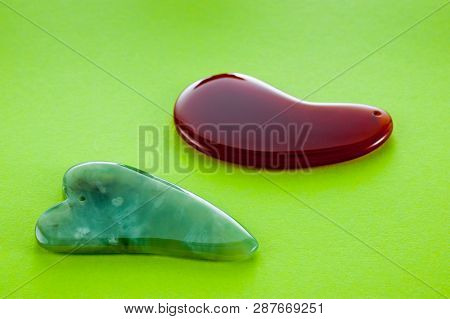 Guasha Scrapers For Body Massage According To The Ancient Method Shot On A Bright Green Background