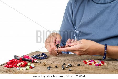 Jewelry Making. Making Bracelet From Multi-colored Beads On A Rough Wooden Table.