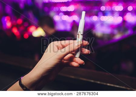 Electronic Cigarettes, Technology Cigarette. Tobacco System Iqos. Female Hand On Blurred Background 