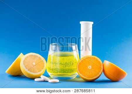 Vitamin Pills. Vitamins With Fruit Flavor. Vitamin C, Lemon, Orange, White Conteiner For Pills On Bl
