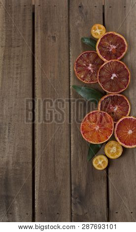 Blood Oranges And Kumquat Slised On Wooden Background