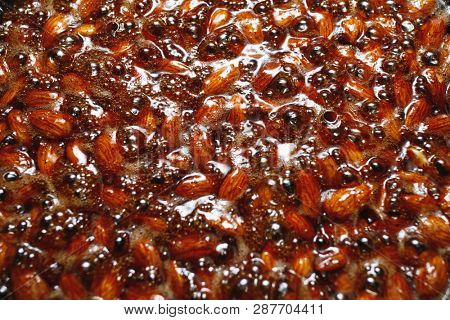 roasted almonds with cinnamon sugar cooking process, top view close-up