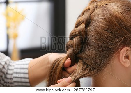 Professional Coiffeuse Braiding Client's Hair In Salon, Closeup