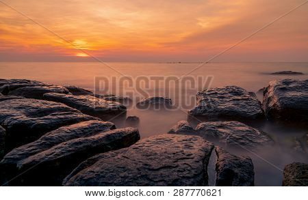 Rocks On Stone Beach At Sunset. Beautiful Beach Sunset Sky. Twilight Sea And Sky. Tropical Sea At Du