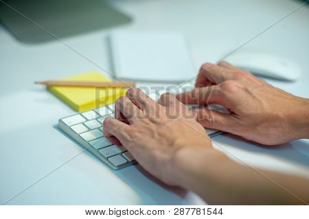 Closeup Selective Focus On Hands Of Businessman Typing On The Keyboard With Defocused Stationaries I