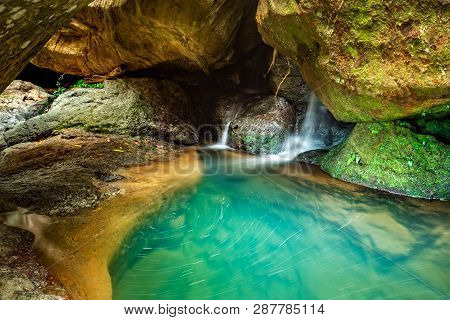 Beautiful Waterfall Flowing Through Rocky Crevices Into A Deep Pool Of Crystal Clear Water That Just