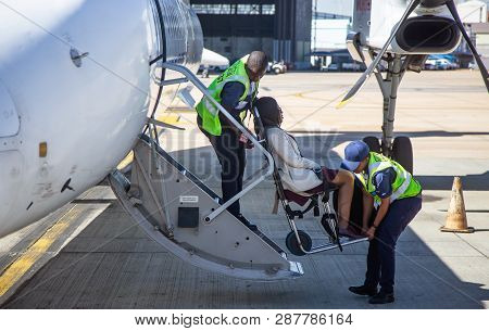 Johannesburg, South Africa, 28th February - 2019: Disabled Passenger Being Helped To Board Aircraft