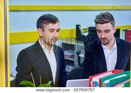 Two Mature Caucasian Male Working In The Office