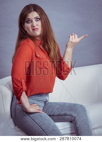 Angry, Pissed Off Young Woman. Attractive Female With Long Brown Hair Sitting On Sofa Being Mad And 