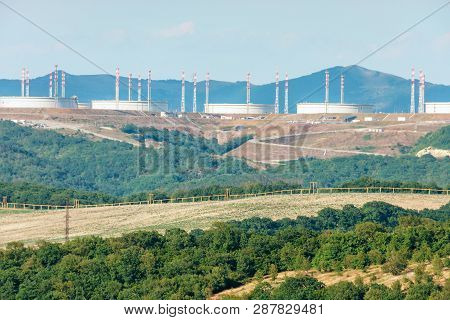Novorossiysk, Russia - June 12, 2018: Sunny Landscape Of Caucasus Mountain Foothills And Oil Tanks A