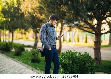 Professional Photographer With Leater Strap And Best Camera Use Phone To Call Model. Photographer Wa