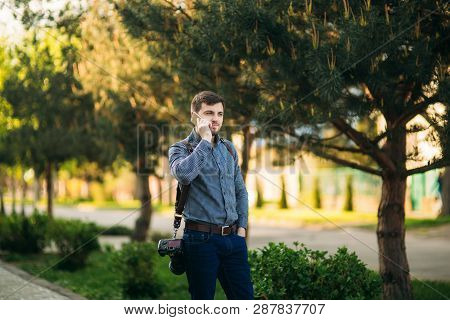 Professional Photographer With Leater Strap And Best Camera Use Phone To Call Model. Photographer Wa