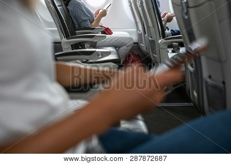 Passangers in abord a commercial flight using their cell phones during flight
