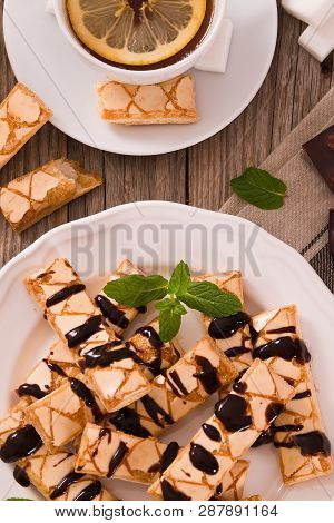 Puff Pastry Cookies With Chocolate Icing On White Dish.