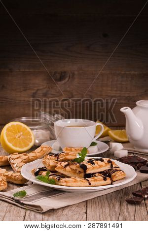 Puff Pastry Cookies With Chocolate Icing On White Dish.
