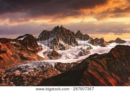 Drammatic landscape with sunset in high snowy mountains