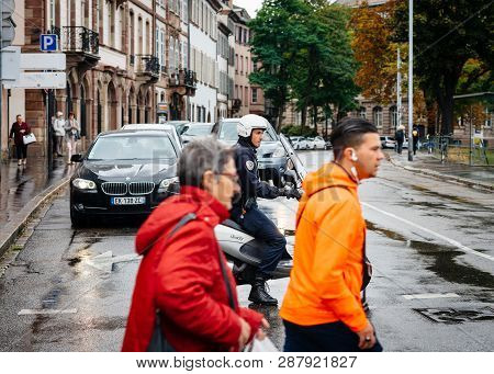 Strasbourg, France - Sep 12, 2017: Pedestrians Crossing Street In Frong Of Young French Police Offic