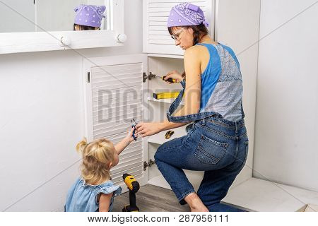 Mother Instead Of Father: Little Daughter Helps Mother To Repair Furniture.