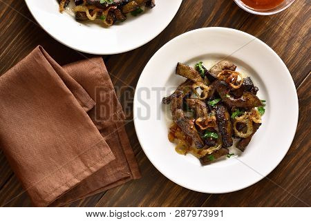 Tasty Fried Beef Liver With Onion On Plate Over Wooden Background. Pieces Cooked Liver (offal) From 