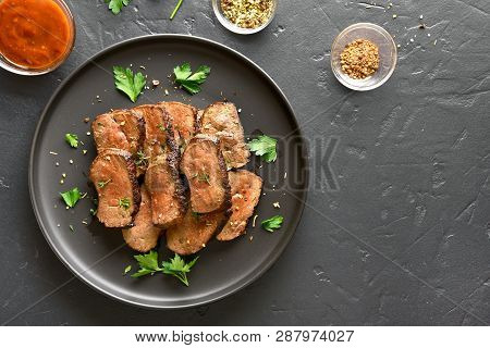 Grilled Sliced Beef Liver On Plate Over Black Stone Background. Cooked Liver(offal) From Beef Meat. 
