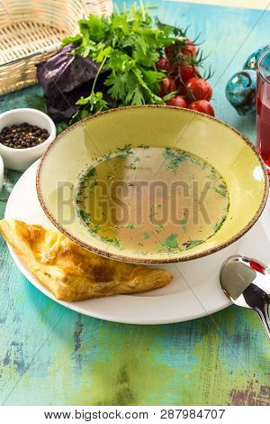Low Fat Chicken Broth With Meatball In Bowl On Blue Wooden Table