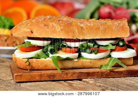 Baguette Sandwich With Egg, Arugula Salad, Tomatoes And Radish